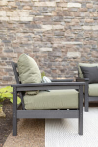 Camden Club Chair and Camden Loveseat in Smoke Gray. Cushions in Heritage Leaf with throw pillows in Heritage Char. Lumbar pillows and LilyHive Rectangular Pouf in Sail Away