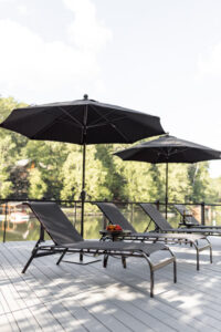 Murphy Chaise Lounges and Murphy End Tables in Black with sling in Augustine Ebony. Umbrellas in Canvas Black 2