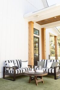 Nordic High Back Loveseats in Matte Black. Harbor 38” Conversation Table in Black on Brazilian Walnut. Cushions in Galleon Ebony with throw pillows in Cast Sage, Canvas Natural, and C