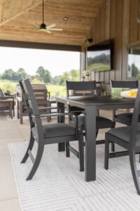 Parker Chair with arm kit in Matte Black with Heritage Char seat cushions. Paired with an 8’ x 11’ Finley Rug and Berkley Expandable Table